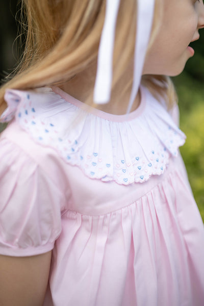 Close up of girl wearing Grace and James Kids Birdie Dress with Heart Embroidery for valentines